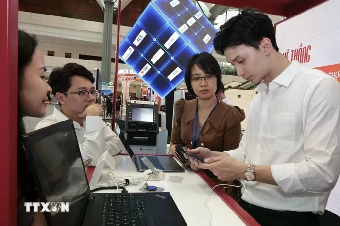 Hướng dẫn khách hàng làm sử dụng dịch vụ online tại Hội nghị Chuyển đổi Số ngành Ngân hàng năm ngoái. Ảnh: Trần Việt/TTXVN